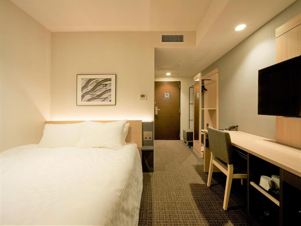 東京にあるTmark City Hotel Tokyo Omori - Vacation STAY 26381vのベッドとデスクが備わるホテルルームです。