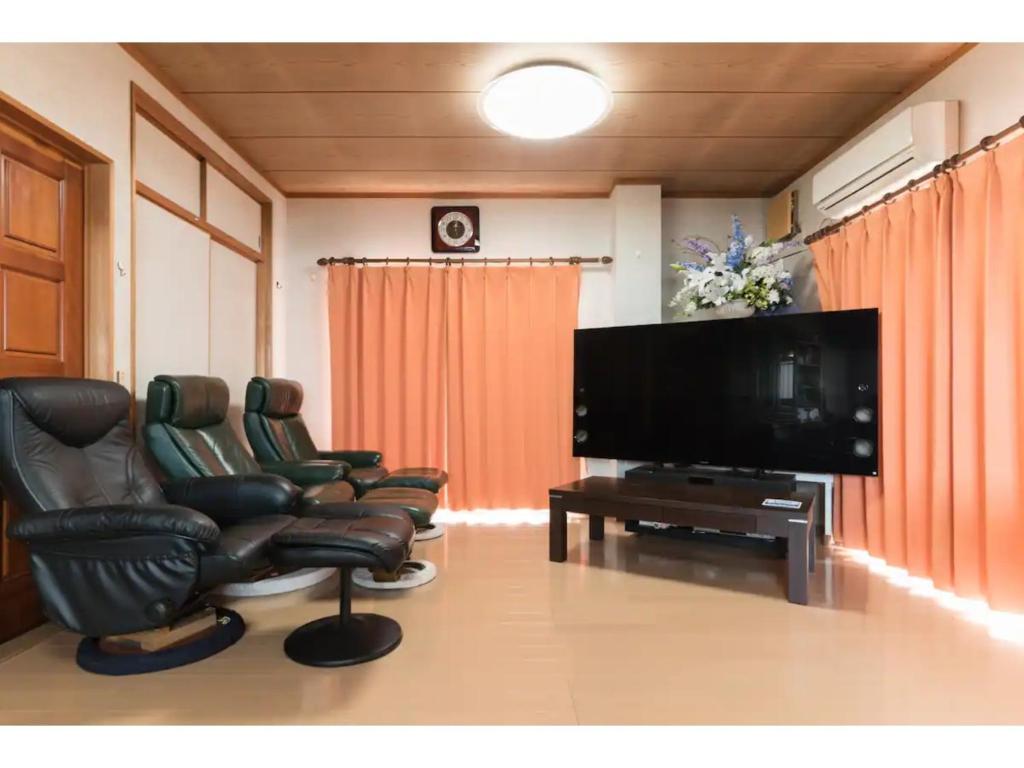 a living room with two chairs and a flat screen tv at Yado wa Good Rich - Vacation STAY 30399v in Tokushima
