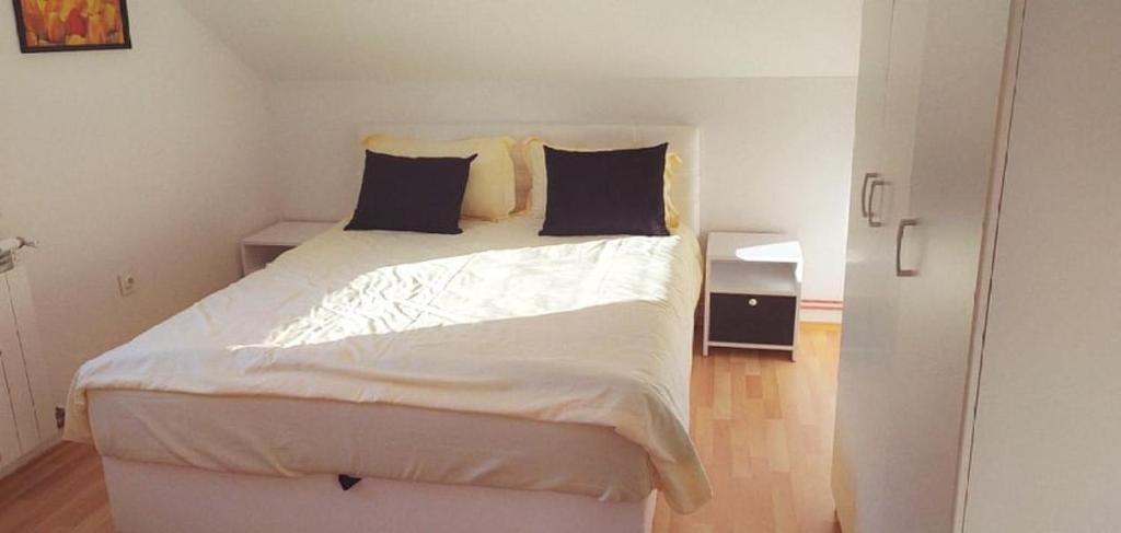 1 dormitorio con 1 cama blanca y 2 almohadas en VISOKO Room en Visoko