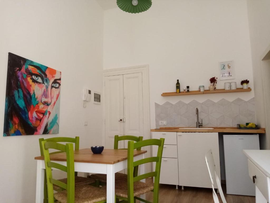 kuchnia ze stołem i 4 zielonymi krzesłami w obiekcie ROUTE 64 MONOPOLI - EAST - Historic Center w mieście Monopoli