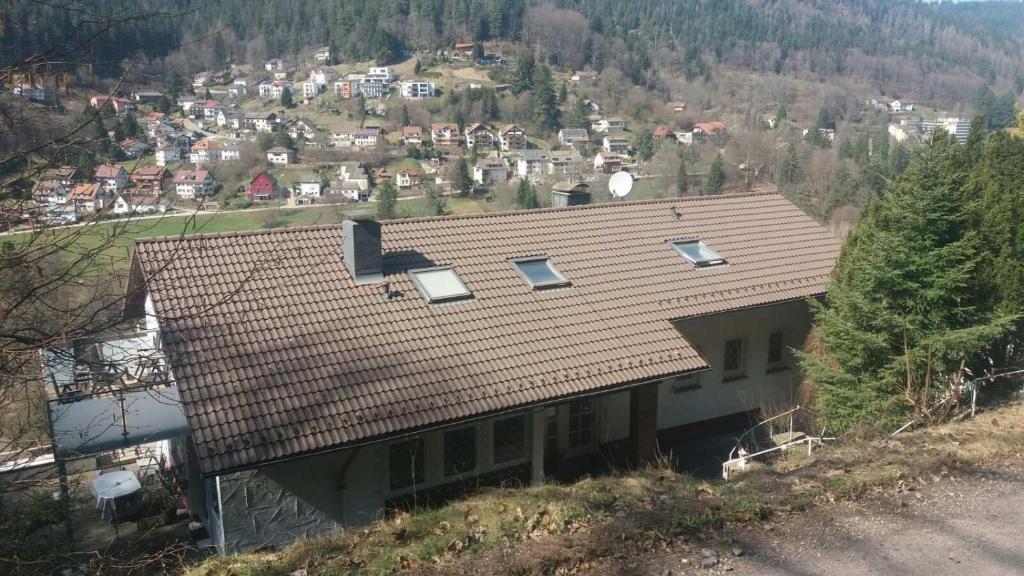 a house with a roof on top of a hill at Ferienwohnung in ruhiger Waldrandlage in Bad Wildbad