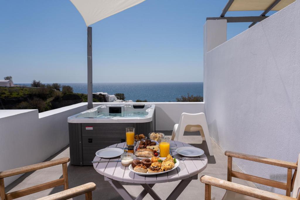 a table with a plate of food on a balcony at Red Beach Harmony suites Sotiria in Akrotiri