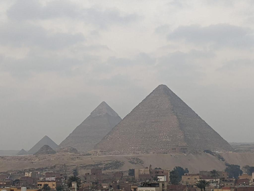 a view of the pyramids of giza and a city at pyramids view suite/vista piramidi in Cairo