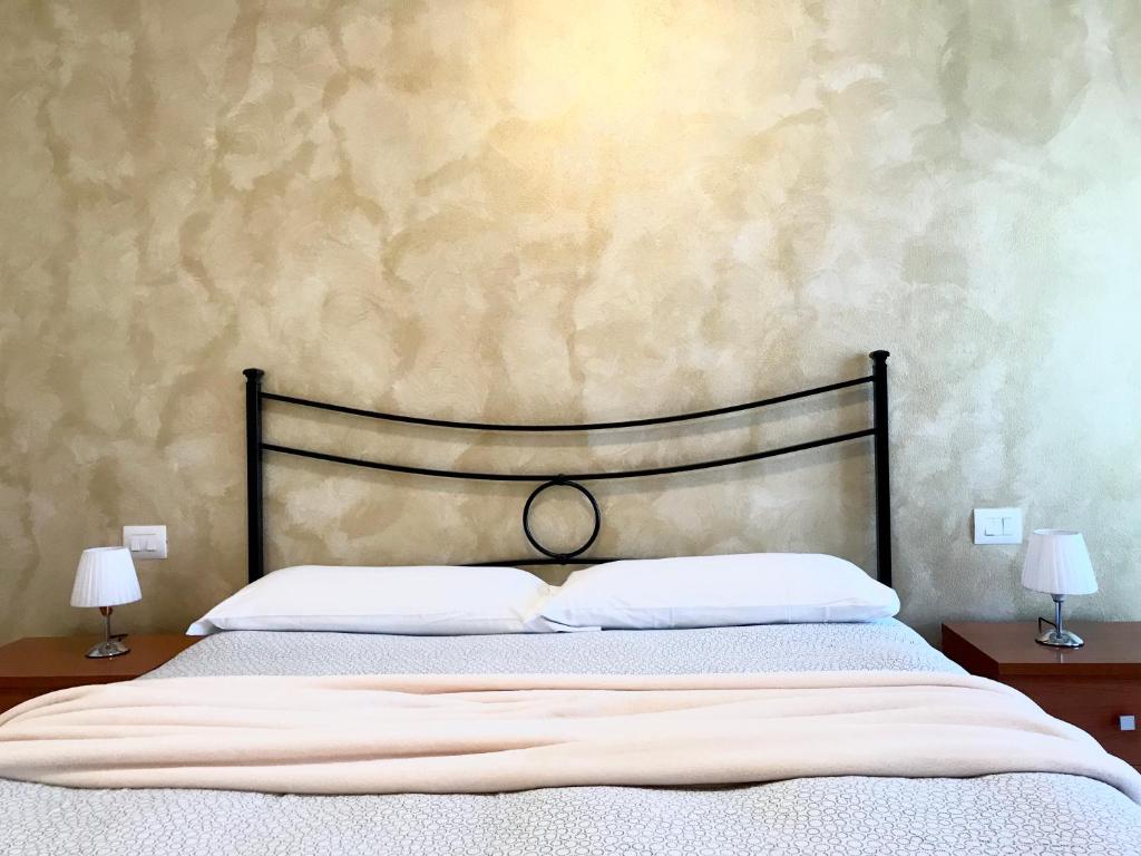 un letto con 2 cuscini bianchi e 2 lampade di Appartamenti Angelica 2 a Pisa