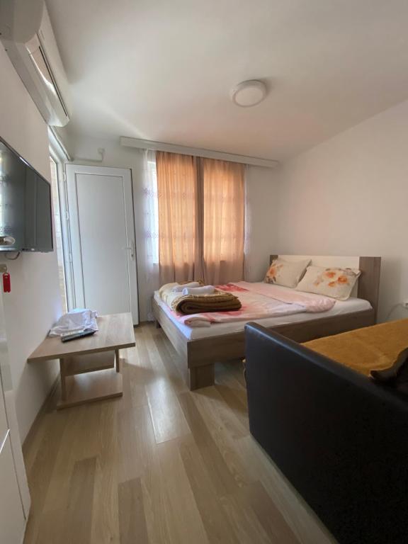 um pequeno quarto com uma cama e uma mesa em Venecia Plaza Struga em Struga