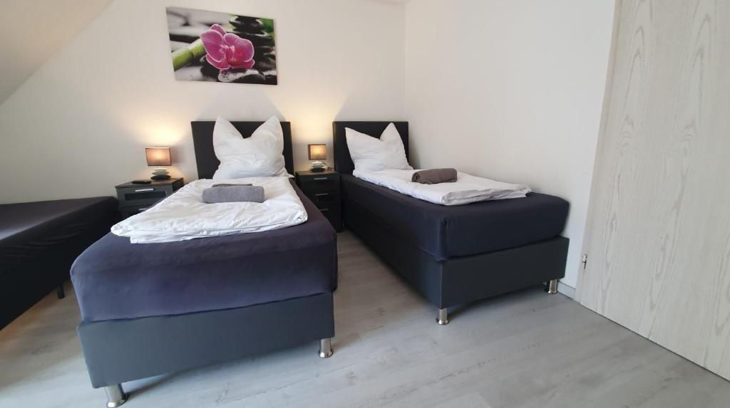 two beds and a ottoman in a room at Neuburg City Apartments in Neuburg an der Donau