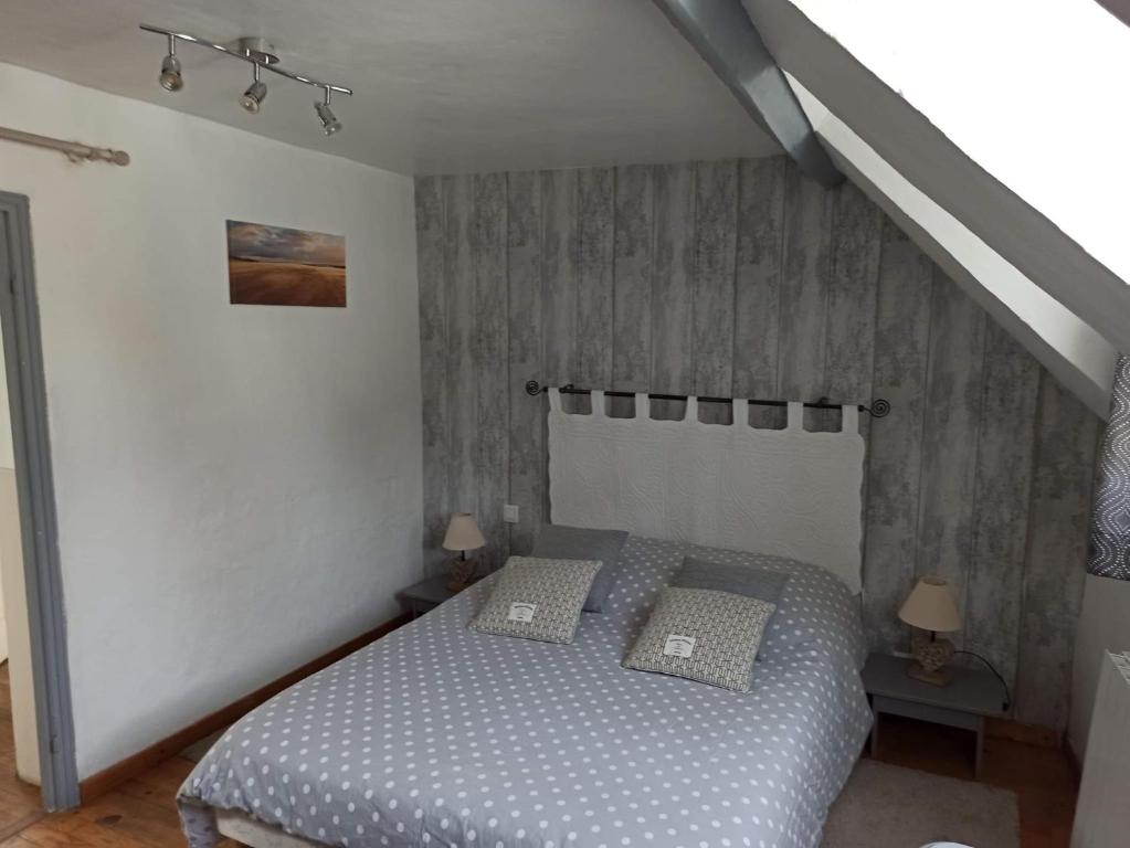 1 dormitorio con 1 cama con 2 almohadas en L'Estacade : maison de pecheur, en Saint-Valery-sur-Somme