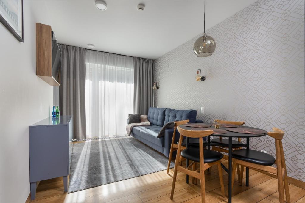 sala de estar con sofá azul y mesa en Apartament Mechelinki en Mechelinki