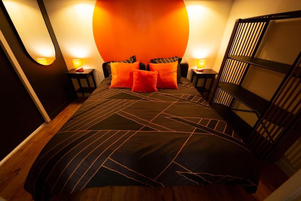 - une chambre avec un lit aux murs orange et des oreillers orange dans l'établissement Etape Urbaine - Toulouse centre - Parking inclus, à Toulouse