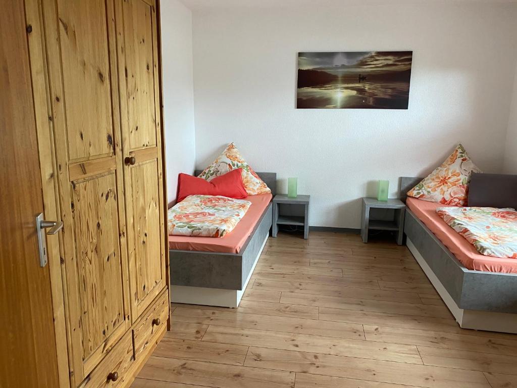 a room with two beds and a door at FEWO Schmandin Laacher See in Wassenach