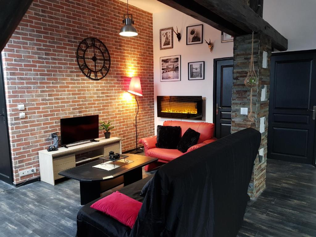 a living room with a red couch and a brick wall at Cosy Lodg in Bourogne
