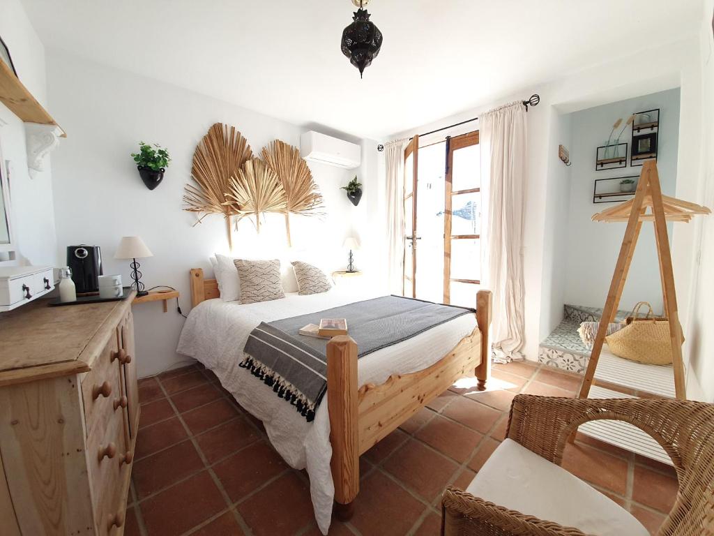 a bedroom with a bed and a large window at Casa Maroma in Cómpeta
