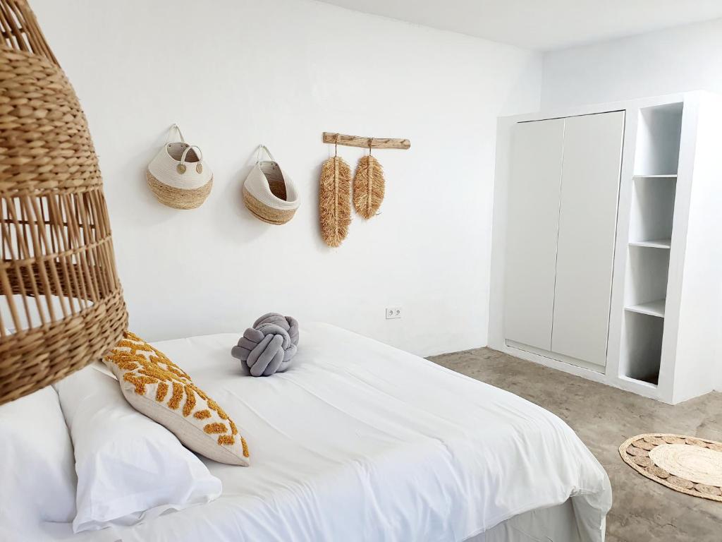 um quarto com uma cama com chapéus na parede em Apartamento con vistas al oceano em Tías