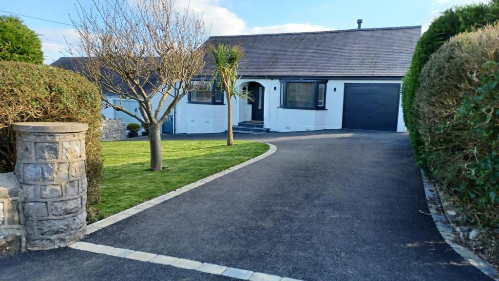 Westbourne by the sea, Benllech, Anglesey. في ينليش: ممر يؤدي إلى منزل مع مرآب للسيارات