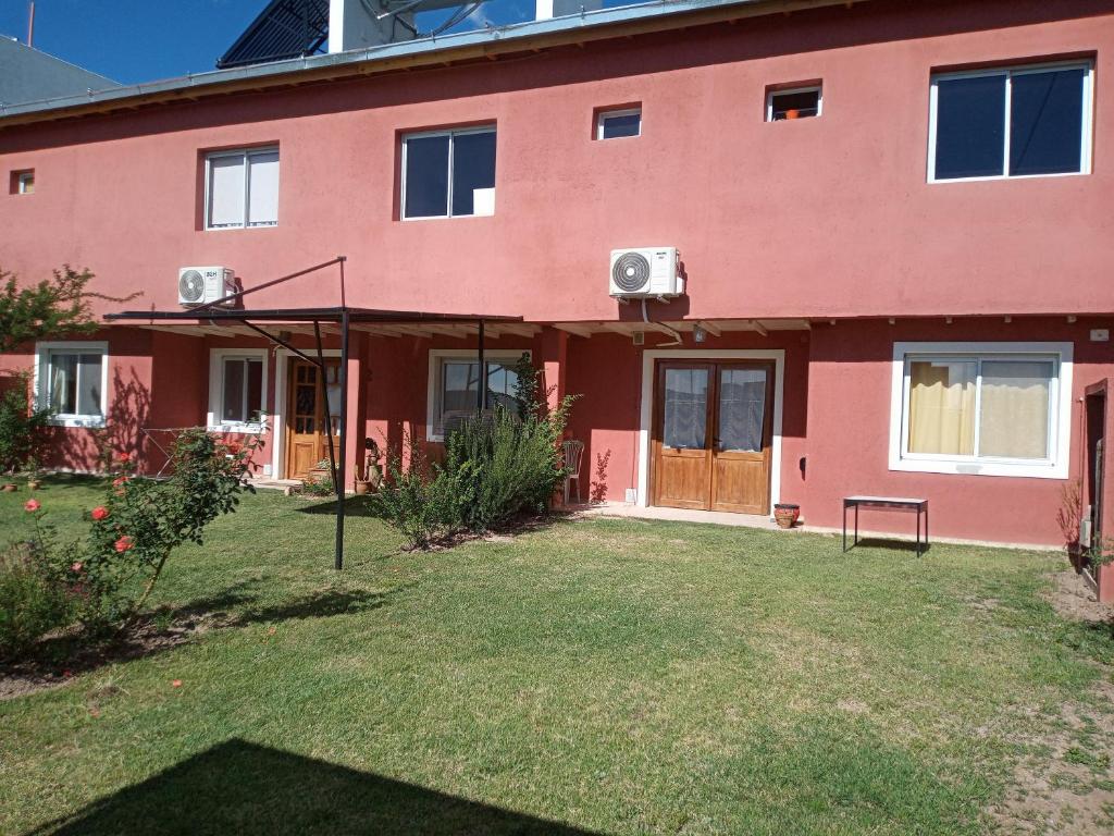 a red house with a yard in front of it at Luz de las Sierras 2 in Arroyo de Los Patos