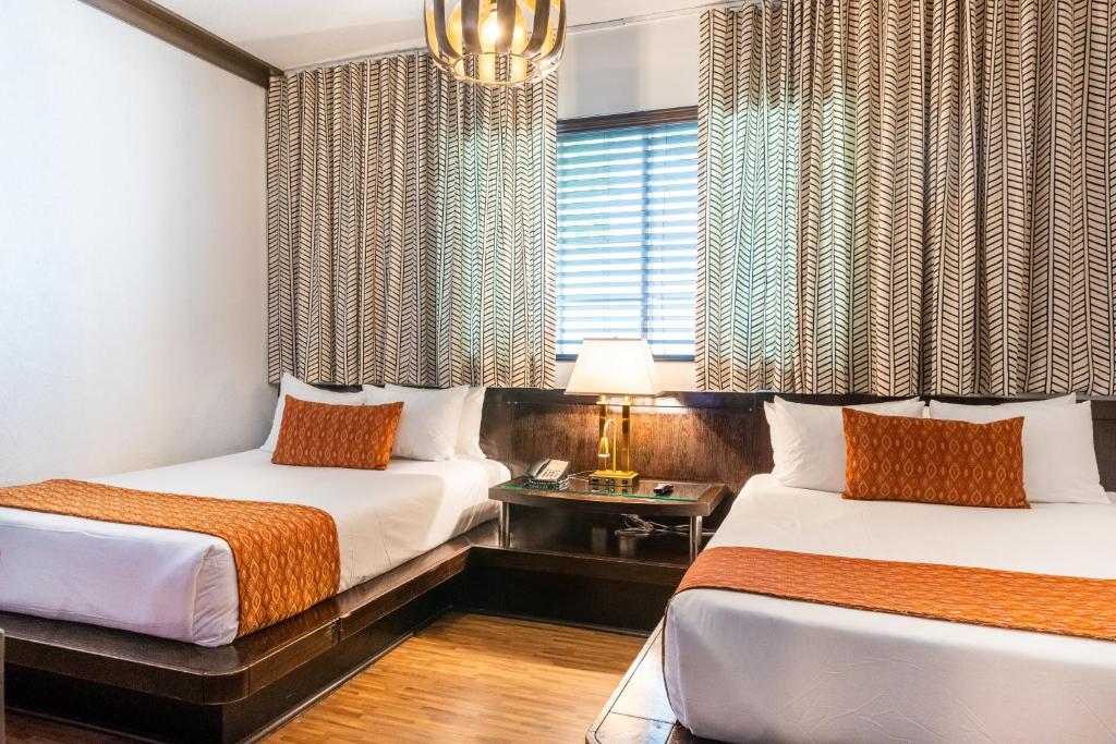 um quarto de hotel com duas camas e uma janela em Hotel Chelsea em Miami Beach