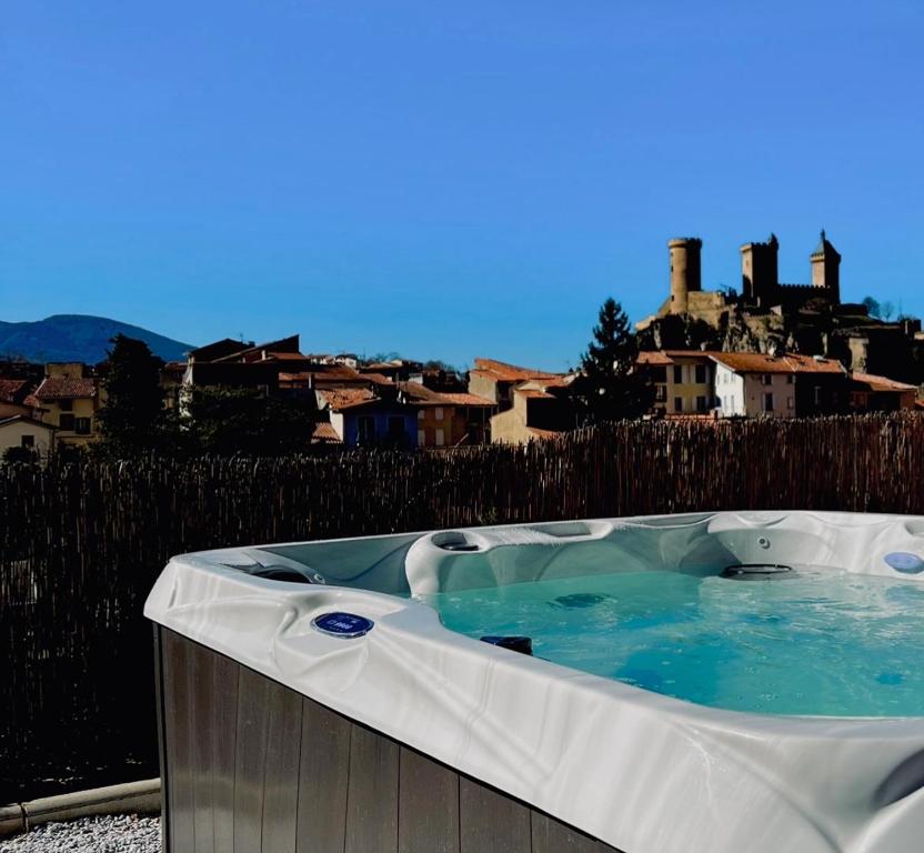 une baignoire jacuzzi avec une ville en arrière-plan dans l'établissement LOFT et SPA sous les étoiles, à Foix
