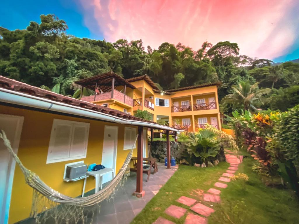 a house with a hammock in front of it at Pousada Porto Girassol in Abraão