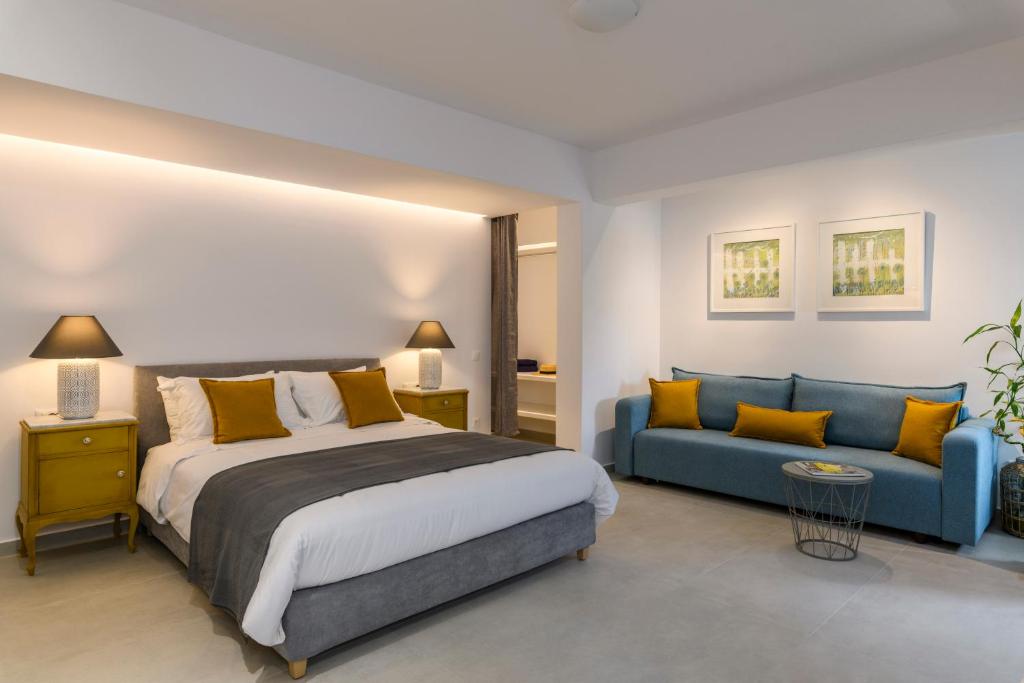 1 dormitorio con 1 cama y 1 sofá azul en Blueisla GREY Studio Town Mykonos, en Mykonos ciudad