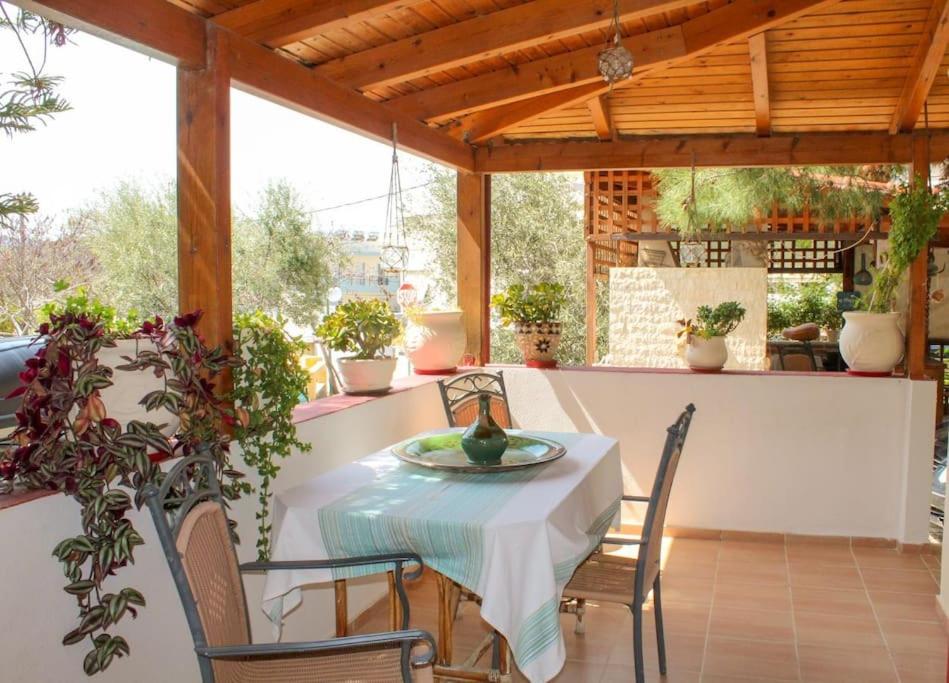 une terrasse couverte avec une table et des chaises. dans l'établissement Afroditi's Guest House, à Héraklion