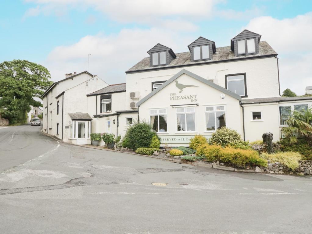 a large white house with a street in front of it at Fernleigh Cottage in Holker