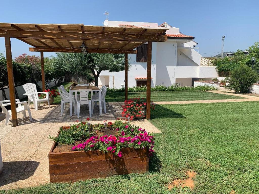 a garden with a wooden pergola and a table with flowers at Sperlonga Shores in Sperlonga