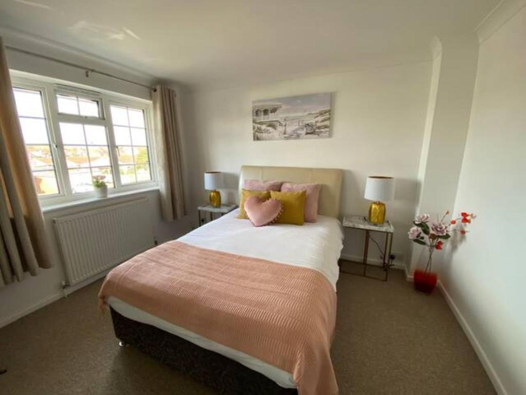 a bedroom with a large bed with two windows at Holes Bay Nature Reserve, Poole, right next to the Water in Hamworthy