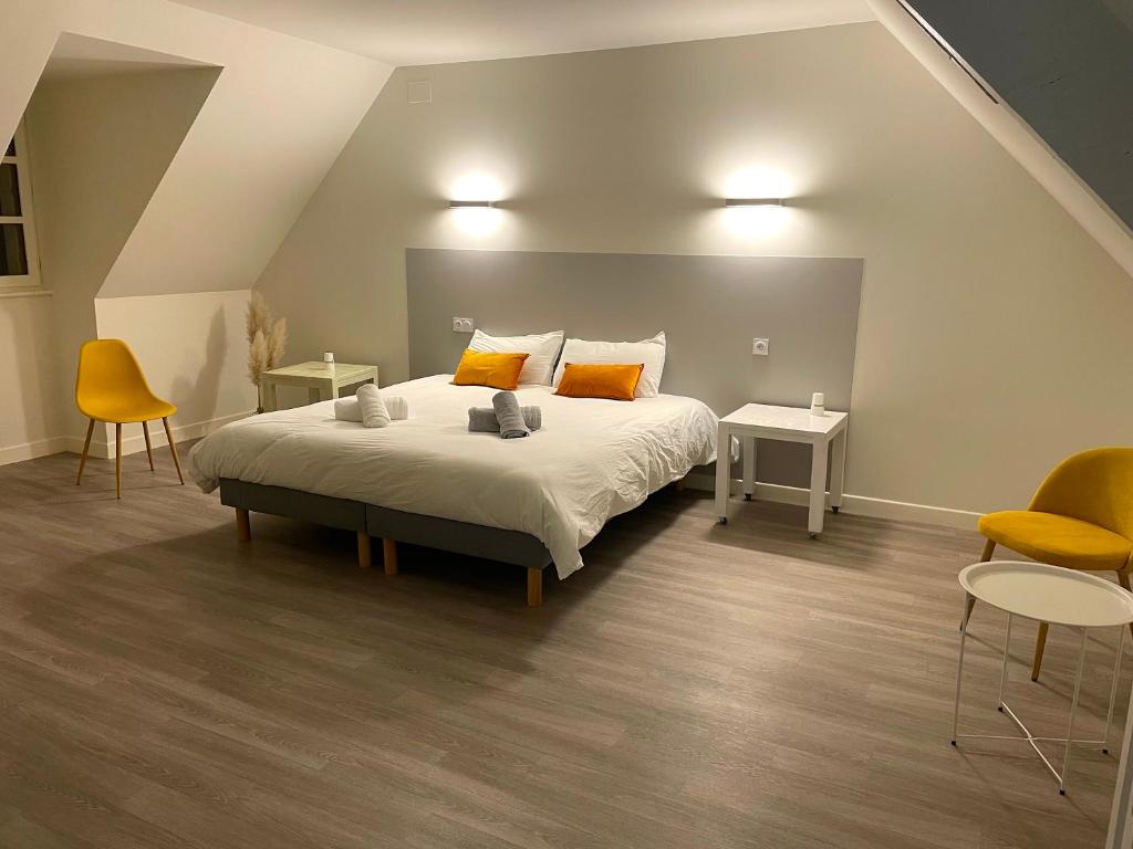 a bedroom with a bed and two tables and chairs at Résidence Haut 2 Gammes - Gîte de séjour in Saint-Hippolyte