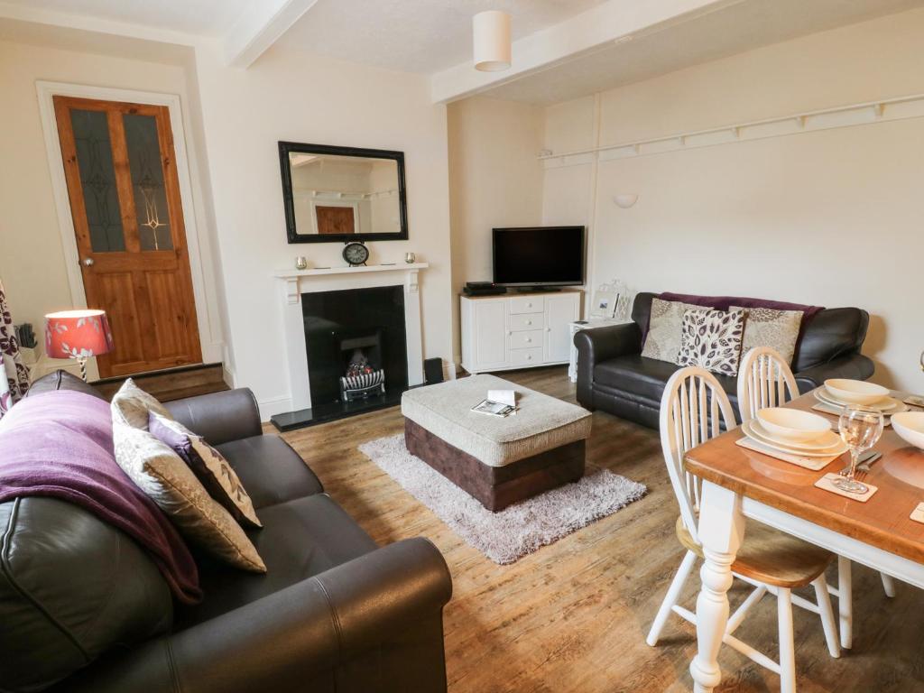 a living room with a couch and a table at Worth Valley Cottage in Haworth