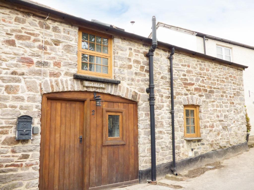 a brick building with a wooden door and windows at 2 Huxtables in North Molton