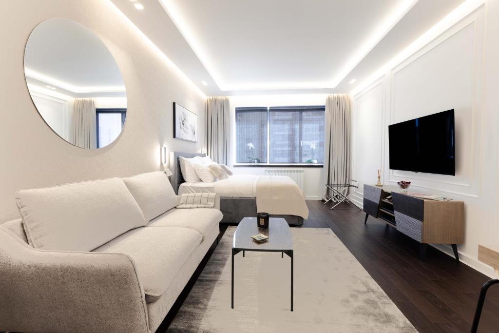 A Blok Top Living في بلغراد: غرفة معيشة مع أريكة بيضاء وسرير