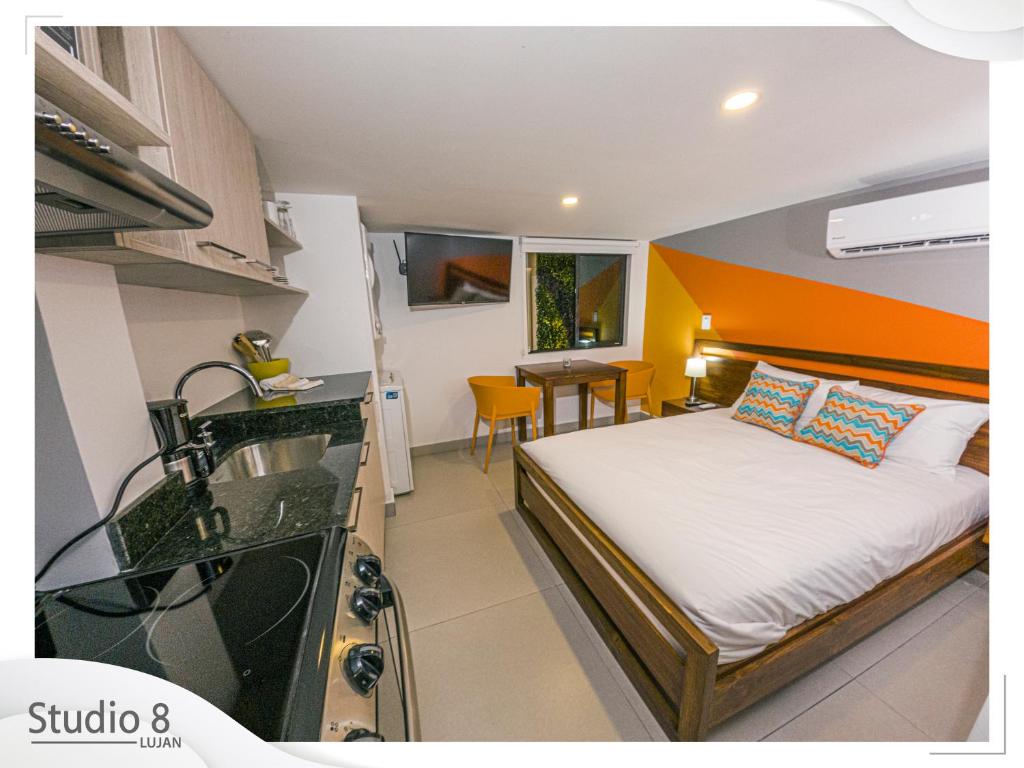 Il comprend une chambre avec un lit et une cuisine avec un évier. dans l'établissement Studio8 Lujan Apartament # 2, à San José