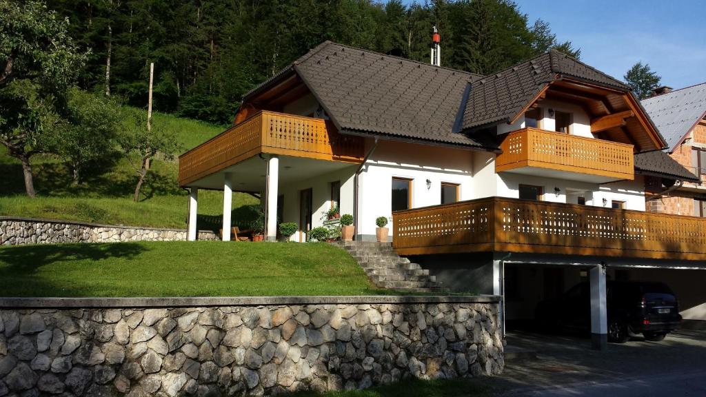 uma casa com uma varanda e uma parede de pedra em Apartment Brumec em Bohinj