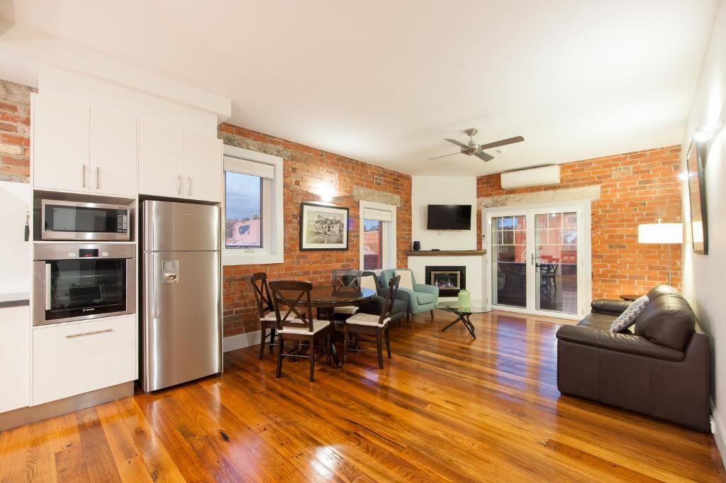 a kitchen and living room with a brick wall at The Bank Apartment - Echuca Holiday Homes in Echuca