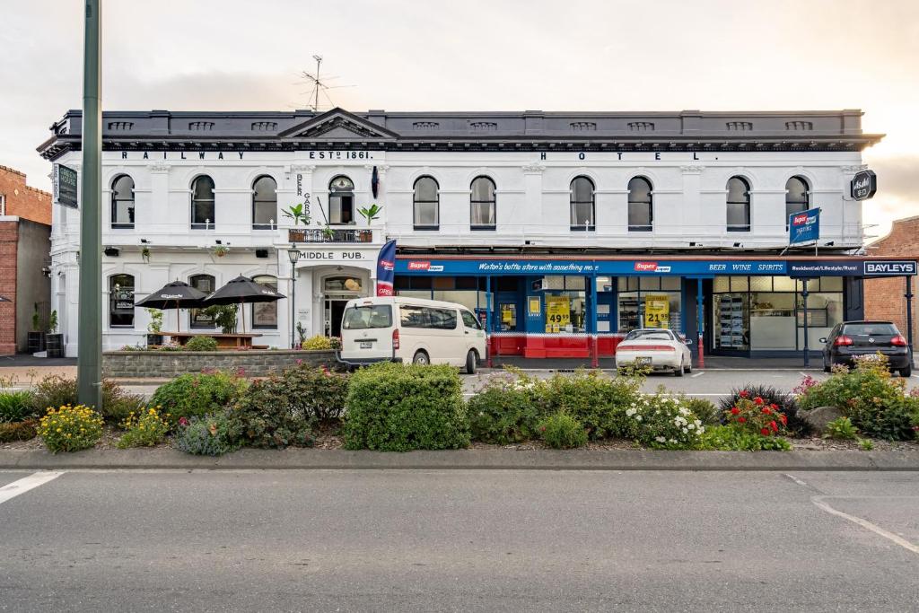 um edifício branco com carros estacionados em frente em Railway Hotel em Winton