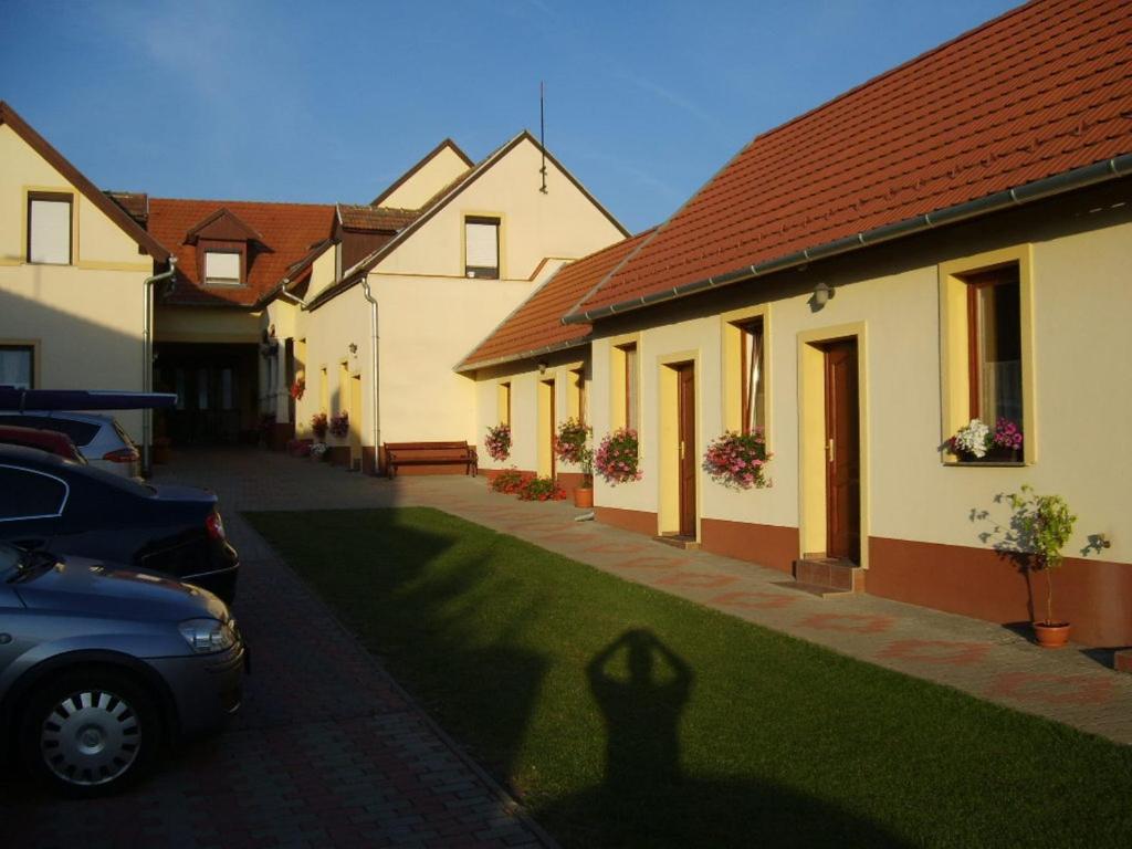 un'ombra di un'auto parcheggiata di fronte a una casa di Szűts Panzió a Fertőrákos