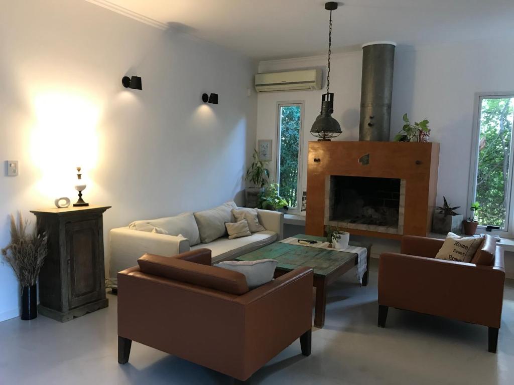 sala de estar con sofá y chimenea en Casona alegre con pileta y patio en San Pedro