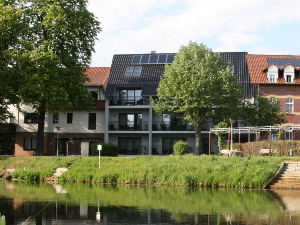 a building with solar panels on it next to a river at Apartment in L bben near the water in Lübben