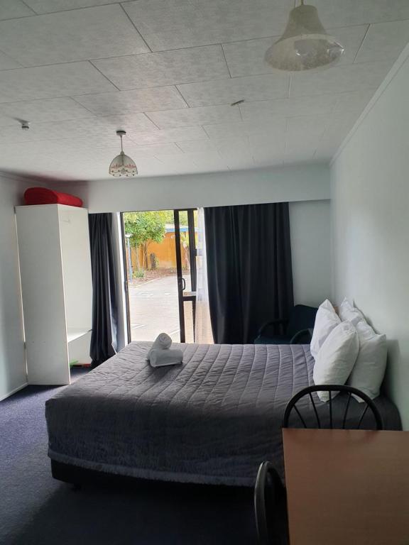 a bedroom with a bed and a large window at Ohakune Court Motel in Ohakune