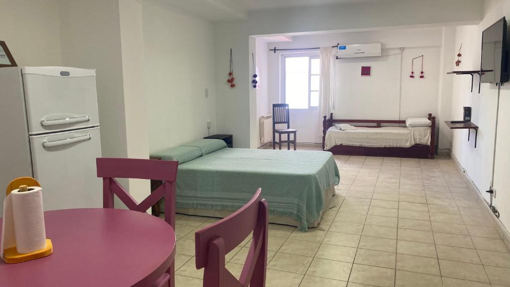 薩爾塔的住宿－Departamento Belgrano 12，带两张床和一张桌子的房间以及一间厨房