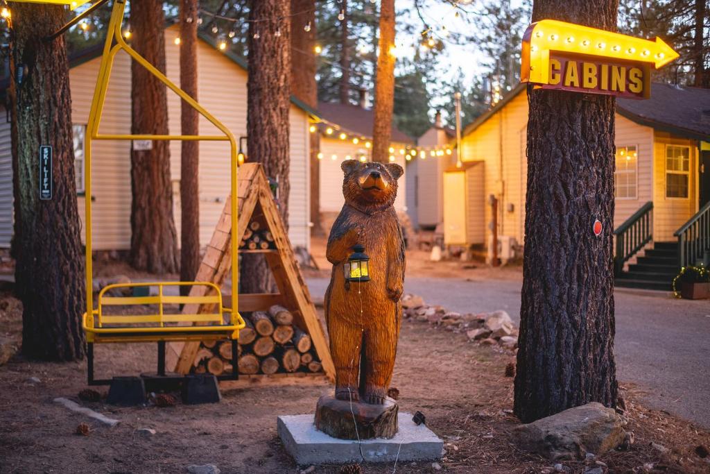 a statue of a bear standing next to a swing at Lakewood Cabins in Big Bear Lake