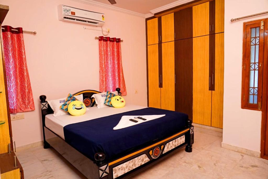 Blue stone homestay guesthouse في فيساخاباتنام: غرفة نوم مع سرير مع وسائد مرحبا كيتي عليه