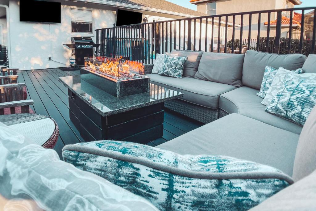 a patio with a couch and a table with a fire place at Sun-Drenched Sojourn in Marco Island