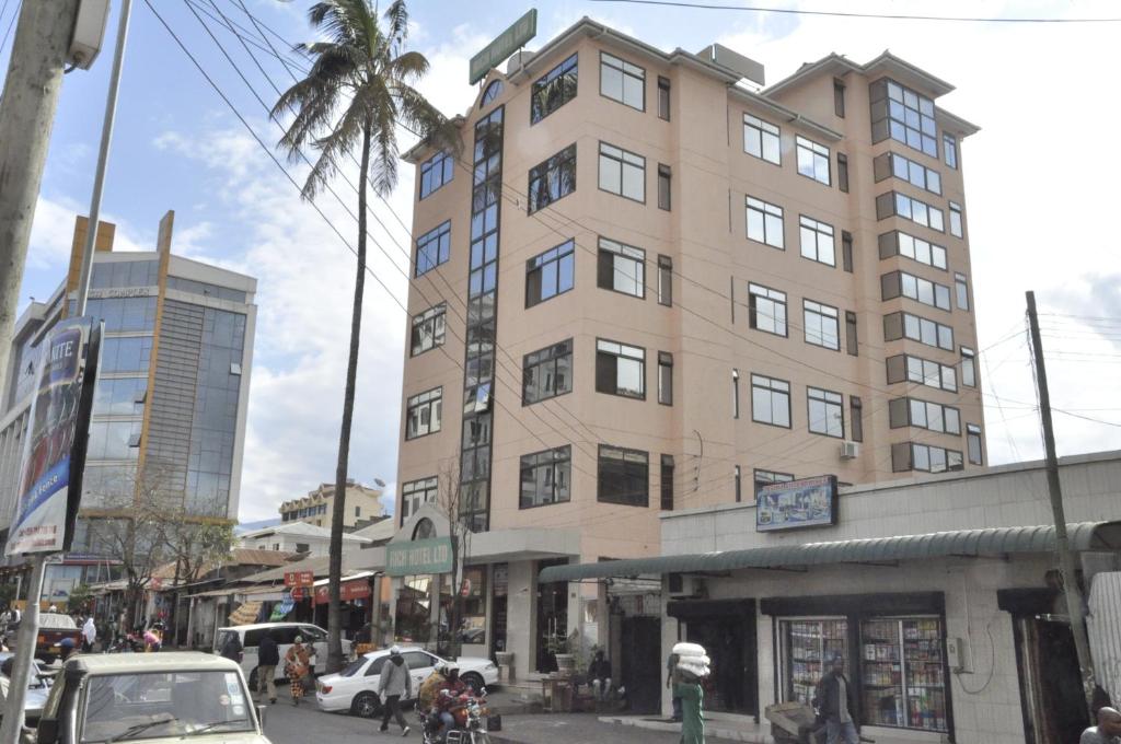 een hoog gebouw op de hoek van een stadsstraat bij Rich Hotel in Arusha