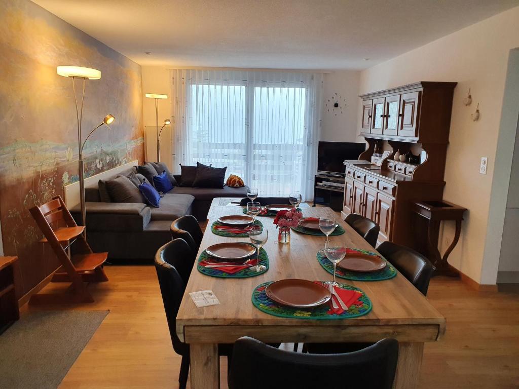 sala de estar con mesa con sillas y sofá en Elfe-Apartments Apartment for 6 guests with patio, en Emmetten