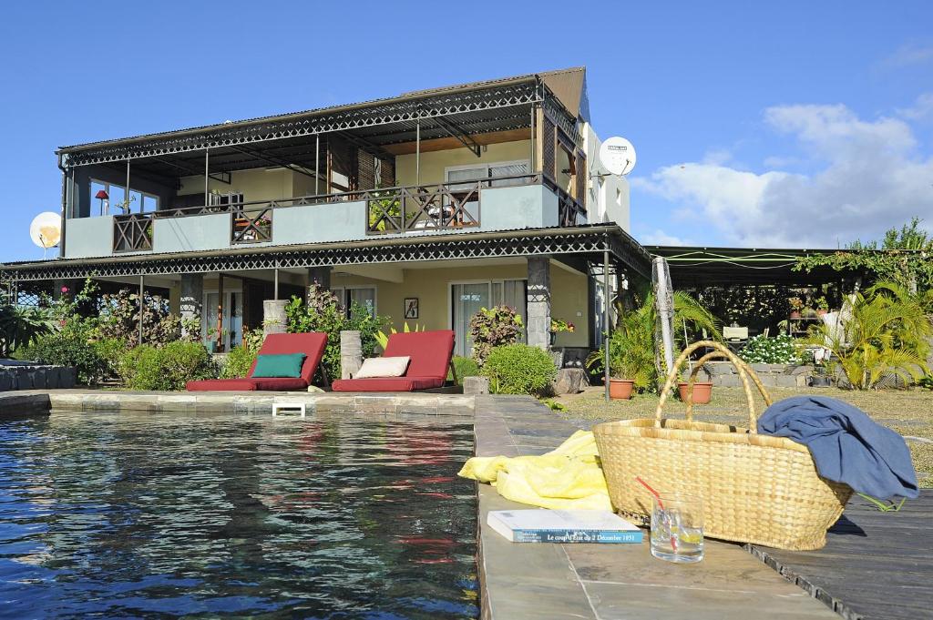 a house with a swimming pool in front of a house at Domaine de La Paix in Rodrigues Island