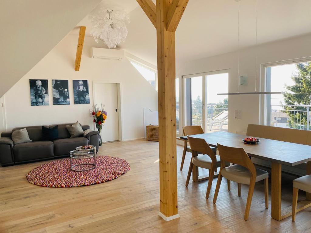 uma sala de jantar e sala de estar com mesa e cadeiras em BodenSEE Apartments Meersburg Sonnhalde em Meersburg