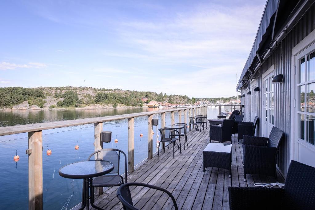 uma varanda com mesas e cadeiras junto à água em Grebys Hotell & Restaurang em Grebbestad
