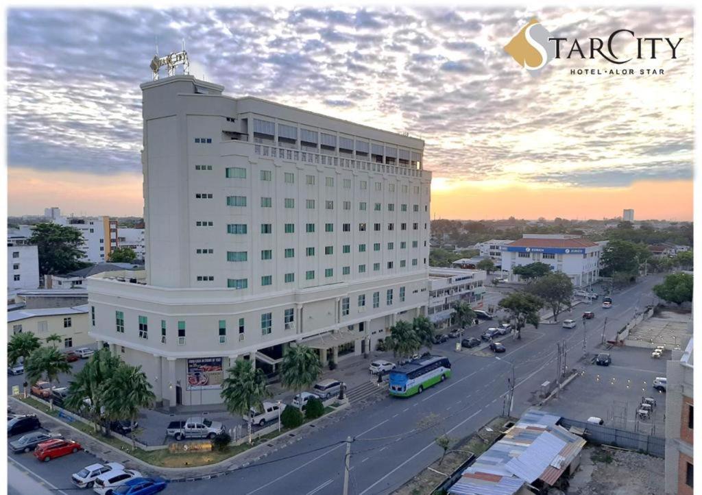 ein großes weißes Gebäude mit einem Parkplatz davor in der Unterkunft StarCity Hotel in Alor Setar