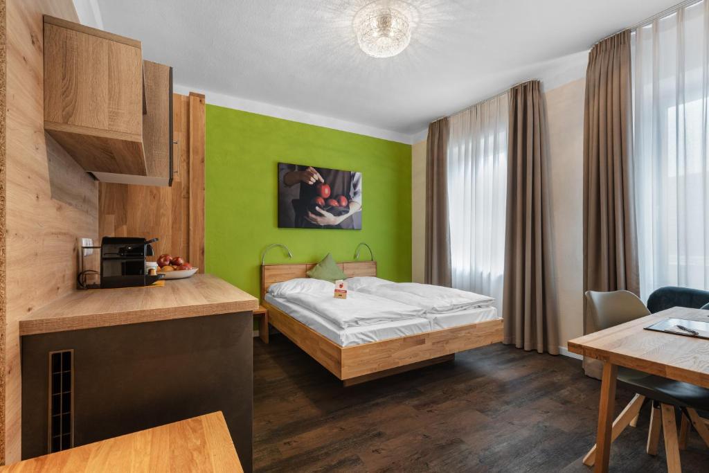 a hotel room with a bed and a table at Schieners Hotel & Apfelhof Apartments in Wemding